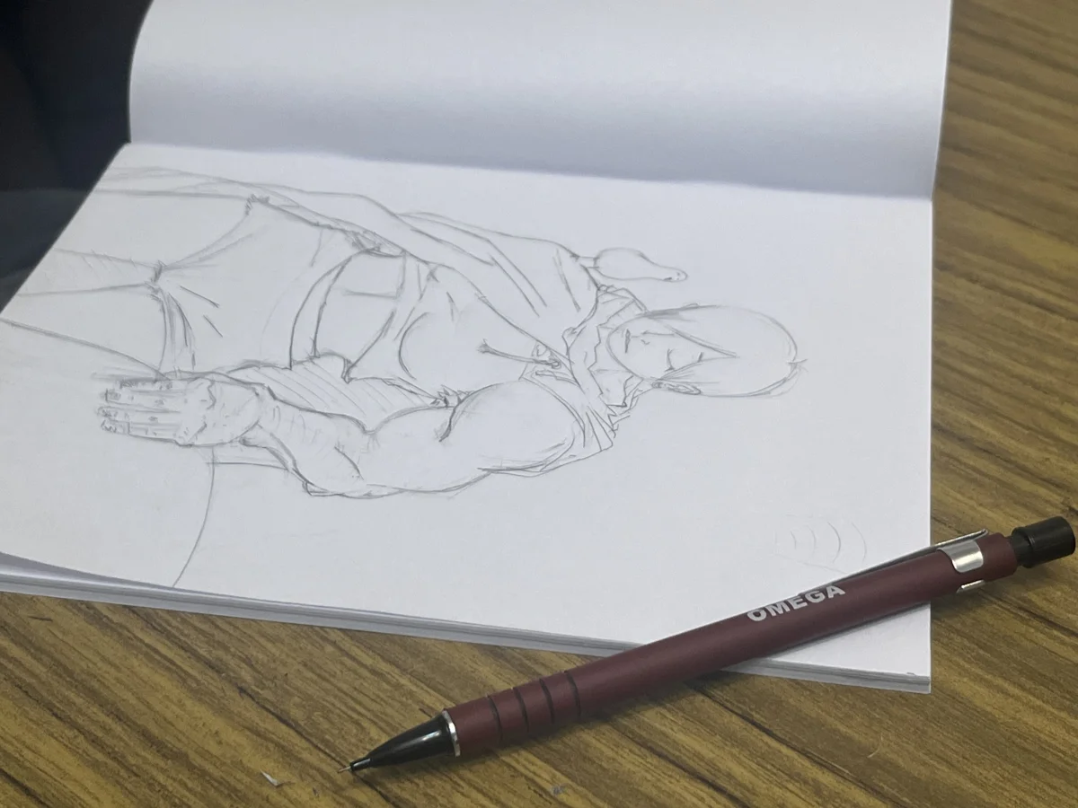 Boceto a lápiz en un cuaderno abierto sobre la mesa.